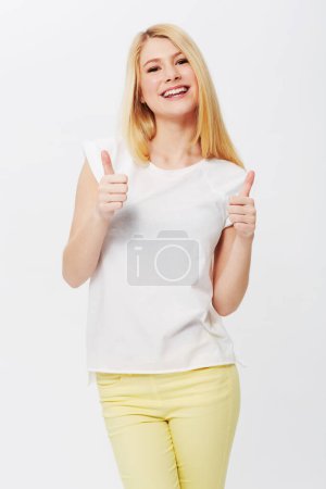 Foto de Mujer feliz, pulgares hacia arriba o sonrisa en retrato de estudio con confianza, sí o éxito por fondo blanco. Chica, orgullosa o modelo con revisión, gesto de mano o acuerdo para ganar, metas o logros. - Imagen libre de derechos