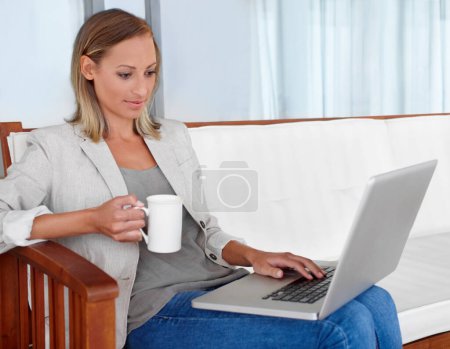 Photo for Laptop, coffee and woman in home for remote work, freelance career and business in living room. House, desk and person on computer for online research, website blog and social networking for job. - Royalty Free Image