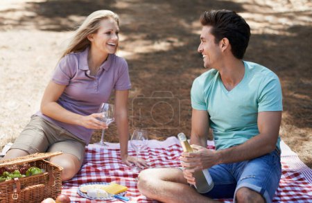 Photo for Couple, picnic and wine glass in nature with love, celebration and summer date or romance for valentines day. Young people with food, fruits and bottle of champagne in woods or forest on anniversary. - Royalty Free Image
