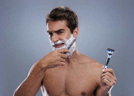 Photo for Man, choice and razor in studio, shaving cream or portrait for grooming by grey background. Person, model and decision for blade with beard, facial hair removal and doubt product for cosmetic change. - Royalty Free Image