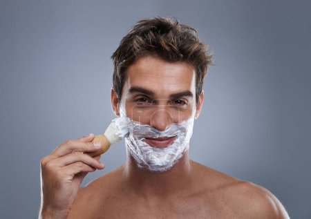 Photo for Man, portrait and shaving cream with brush studio application for healthy skin, hygiene or confidence. Male person, face and beard or fresh hair removal as maintenance care, grey background or mockup. - Royalty Free Image