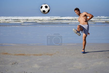 Photo for Man, beach and soccer ball in fitness, exercise or outdoor hobby for surfing or practice. Young male person or sports player kicking on ocean coast for football game, match or friendly by the seaside. - Royalty Free Image