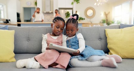 Photo for Black girl children, relax with tablet on sofa and elearning or watching cartoon movie, sisters at home and screen time. Young female kids, streaming online and subscription to education app or film. - Royalty Free Image