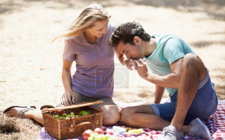 Photo for Couple, relax and eating on picnic in nature for love, care or support on outdoor date on floor mat. Man and woman with fruit basket and enjoying healthy meal, snack or vitamins together in forest. - Royalty Free Image