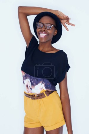 Photo for Fashion, peace sign and black woman on a white background in trendy, stylish and casual clothes. Hand emoji, hipster style and isolated person with tongue out, glasses and cool accessory in studio. - Royalty Free Image