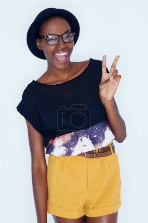 Photo for Fashion, peace sign and portrait of black woman on a white background in trendy, stylish and casual clothes. Hand emoji, hipster style and isolated person with smile, glasses and accessory in studio. - Royalty Free Image