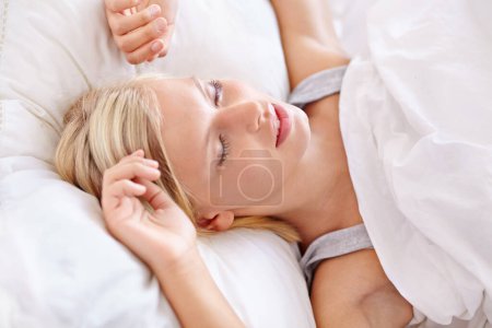 Photo for Peace, sleeping and tired woman in a bed resting, dreaming and comfortable in her home. Eyes closed, face and female person asleep in a bedroom with vacation, holiday or snooze on day off in a house. - Royalty Free Image