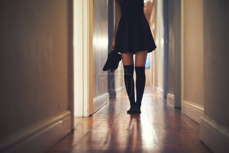 Photo for Woman, legs and walking with shoes in hallway for fashion, clothing or outing at home. Closeup of young female person in dress and leggings by door for sneaking, silence or quiet foot steps at house. - Royalty Free Image