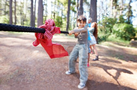 Photo for Pull. Children, game and tug of war in forest, summer camp and holiday with travel and energy outdoor. Kids, adventure and team building with competition, playful and young people in group for fun - Royalty Free Image