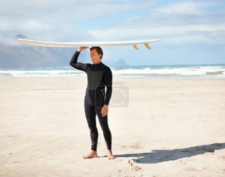 Photo for Surfing, ocean and man at beach with surfboard on head for water sports training, freedom and fitness outdoors. Nature, happy and person for adventure on holiday, vacation and hobby by sea for waves. - Royalty Free Image
