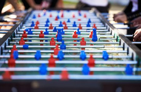 Photo for Foosball table, competitive and leisure with people playing a game outdoor at a music festival together. Party, event or social gathering with friends at a carnival for tabletop soccer or football. - Royalty Free Image