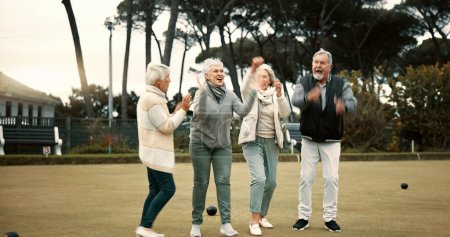 Photo for Bowls, celebration and hugging with senior friends outdoor, cheering together during a game. Motivation, support or applause and a group of elderly people clapping while having fun with a hobby. - Royalty Free Image