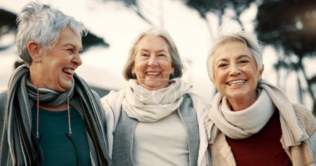 Photo for Talking, laughing and elderly woman friends outdoor in a park together for bonding during retirement. Happy, smile and funny with a group of senior people hugging in a garden for humor or fun. - Royalty Free Image