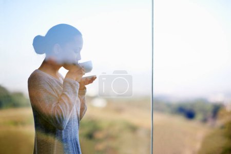 Photo for Woman, coffee with window and balcony outdoor, drink warm beverage with morning routine and zen in nature. Peace, calm and espresso for caffeine, glass and tea cup in countryside for leisure. - Royalty Free Image