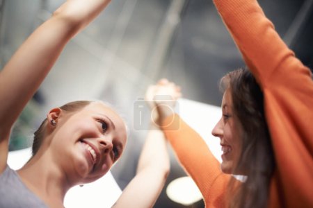 Photo for Women, friends and holding hands with bonding, care and love at a concert with a smile. Happy, people and music festival at event with excited, support and students together at a party with low angle. - Royalty Free Image