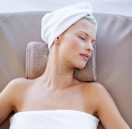 Photo for Young woman, relax and rest in spa for wellness, beauty and peace with body treatment in salon. Person, sleeping or zen on massage bed at luxury resort, detox or comfort for stress free on holiday. - Royalty Free Image
