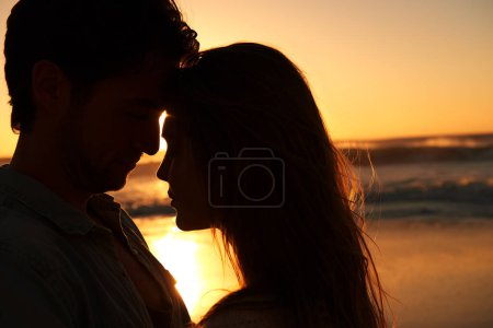 Photo for Couple, beach and sunset or silhouette embrace on vacation for coast holiday, connection or bonding. Man, woman and love hug at sea ocean for summer travel or evening journey, explore or marriage. - Royalty Free Image