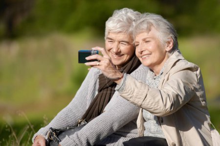 Téléchargez les photos : Amis seniors, plein air et selfie pour la photographie, l'image et heureux pour les souvenirs dans la nature et les personnes âgées. Les femmes, coller et bavarder avec sourire, drôle et rire ensemble à la retraite. - en image libre de droit