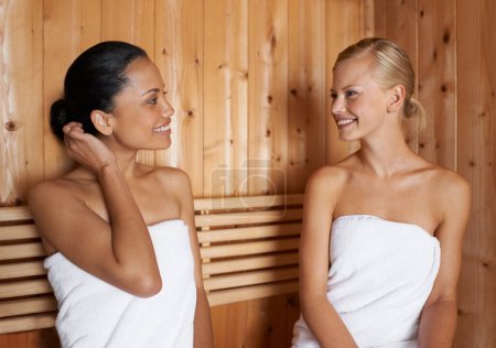 Téléchargez les photos : Femmes, parler et se détendre dans le sauna au spa avec désintoxication saine de la sueur pour la beauté, le bien-être et les soins de la peau. Amis, traitement et assis dans un hammam avec un sourire pour des avantages anti-âge pour le corps. - en image libre de droit