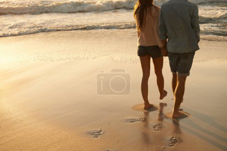 Photo for Beach, sunset and couple holding hands on walk, sand journey or travel holiday for outdoor wellness in Portugal. Mockup space, love and back of partner, soulmate or people on romantic tropical island. - Royalty Free Image