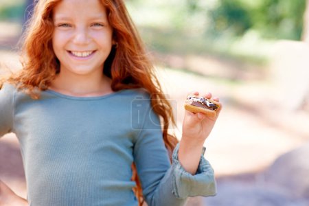Photo for Happy, child and portrait of eating smores outdoor, camping and relax at barbecue with dessert or cookie. Girl, smile and hungry for biscuit with marshmallow in woods or forest on holiday or vacation. - Royalty Free Image