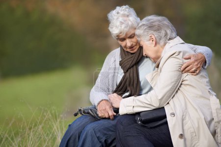 Téléchargez les photos : Femmes âgées, amis et embrasser dans la nature, liens et chagrin dans un environnement extérieur. Personnes âgées, jardin et confort dans un parc paisible pour l'affection, la tristesse et les câlins pour les soins à la retraite. - en image libre de droit