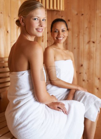 Foto de La belleza, el retrato y las mujeres se relajan en la sauna en el spa para una desintoxicación saludable del sudor para el bienestar de la piel. Feliz, tratamiento y amigos sentados juntos en la sala de vapor de lujo para anti envejecimiento beneficios para el cuerpo. - Imagen libre de derechos