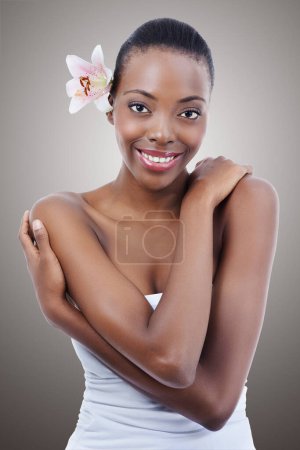 Photo for Portrait, beauty and flower with self love black woman in studio on gray background for natural skincare. Smile, hug and orchid with happy young model at spa for aesthetic wellness or cosmetics. - Royalty Free Image