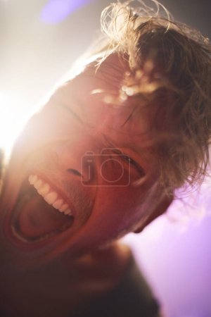 Photo for Portrait, closeup and man screaming for rockstar performance at concert for entertainment at night. Culture, yelling and face of musician male person with energy at festival for artistic expression. - Royalty Free Image