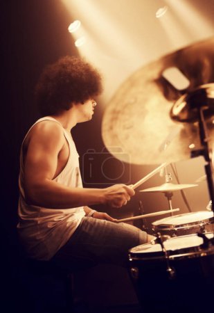Photo for Stage, drummer and man in performance at concert playing jazz, beat and talent for music. Drums, musician and person in theater spotlight with instrument for percussion, rhythm and show at night. - Royalty Free Image