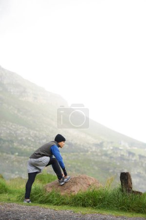Photo for Fitness, nature and a man stretching for a run, exercise or morning workout in the morning. Thinking, sports and a male runner or athlete with a warm up on the road for the start of training. - Royalty Free Image