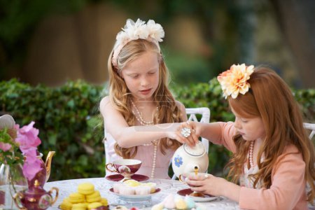 Photo for Playing, tea party and girl children in garden for pretend with cake, flowers or kid fun. Princess, cookies and fantasy with friends, teapot and backyard with celebration, imagination and drink - Royalty Free Image