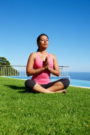 Photo for Meditation, yoga and woman on grass praying for holistic balance, mindfulness and breathing exercise. Meditating, hands in prayer and person by ocean for wellness, health and zen energy outdoors. - Royalty Free Image