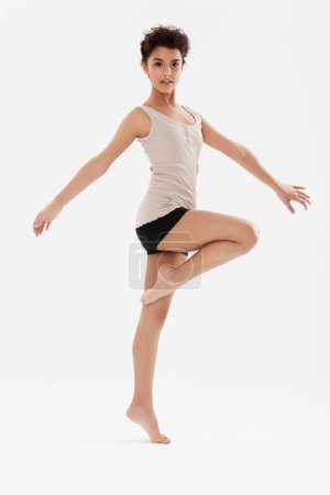 Foto de Danza, ballet y retrato de mujer sobre fondo blanco para performance, fitness y entrenamiento teatral. Bailarina, bailarina y persona aislada para el equilibrio, rutina creativa y práctica en estudio. - Imagen libre de derechos