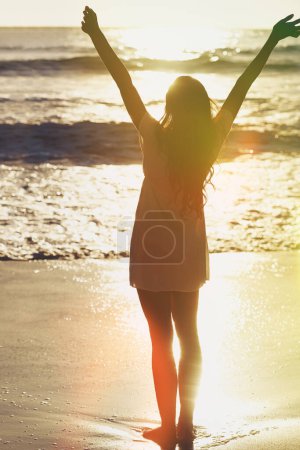 Téléchargez les photos : Coucher de soleil, plage et femme étirant les bras avec de l'eau, la liberté et excité pour les vacances d'été en Australie. Détendez-vous, soleil et fille en vacances avec l'océan aventure, Voyage et se détendre sur l'île tropicale - en image libre de droit