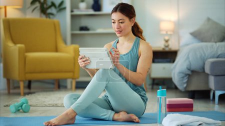 Photo for Fitness, internet and woman streaming on a tablet for training, yoga and exercise on the floor of her house. Happy, young and wellness girl with technology for a workout, cardio or video on pilates. - Royalty Free Image