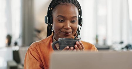 Photo for Black woman, headset and coffee in home office with laptop and remote work and break in apartment. Virtual assistant at desk with computer, drink and relax with freelancer, consultant or crm agent - Royalty Free Image