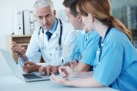 Photo for Laptop, meeting and doctor with nurses in hospital for medical diagnosis or treatment discussion. Team, computer and senior surgeon talking to healthcare workers for surgery research in clinic - Royalty Free Image