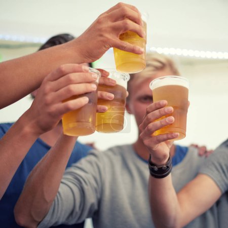 Téléchargez les photos : Mains, bière et groupe d'amis applaudissent pour la fête, la célébration ou l'aventure ensemble. Du plaisir, des boissons et des toasts, des hommes en vacances pour se détendre et se lier d'alcool lors d'un événement de vacances au festival de Munich - en image libre de droit