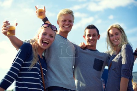 Téléchargez les photos : Portrait, bière et groupe d'amis fête, célébration ou aventure heureuse ensemble sur un angle bas. Sourire, boissons et ciel bleu, hommes et femmes en vacances pour se détendre avec des liens, de l'alcool et des événements de vacances. - en image libre de droit