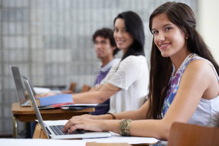 Photo for University, laptop and portrait of woman in classroom typing with smile, learning and future opportunity. Education, knowledge and growth for group of students in college lecture studying for exam - Royalty Free Image