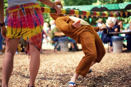 Photo for Limbo, game and person at party outdoor with balance and playing at a music festival, event or challenge. Fun, people and outdoor in woods, forest or person in social activity at party in bear suit. - Royalty Free Image