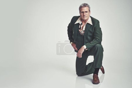 Photo for Portrait, fashion and senior man in style or business outfit on a gray studio background. Mature, male person or model posing with knee on floor in stylish formal clothing or suit on mockup space. - Royalty Free Image