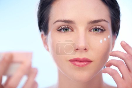 Photo for Portrait of woman, wellness or face cream for skincare, beauty or cosmetics on blue background. Antiaging, studio or model with product application or glow for lotion, dermatology or facial treatment. - Royalty Free Image