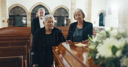 Photo for Senior women, coffin and funeral in church for memory, support and condolences with religion with family. Community, friends and together for death, loss and service with empathy, faith and casket. - Royalty Free Image