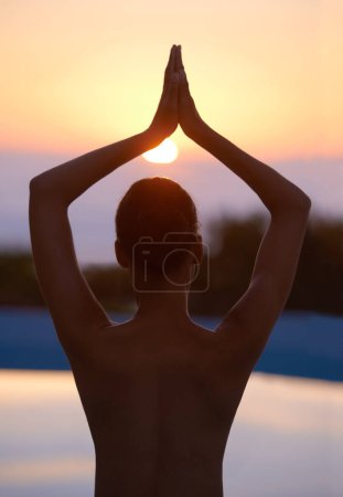 Téléchargez les photos : Arbre, yoga et femme méditent au coucher du soleil au bord de la piscine pour un corps sain, le bien-être et zen en plein air. Vue arrière, pose vrikshasana et personne à l'eau au crépuscule pour se détendre, la paix ou le calme pour l'équilibre. - en image libre de droit