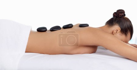 Photo for Health, hot stone and woman with massage at spa for wellness, natural and back treatment. Self care, cosmetic and calm young female person sleeping for warm rock skin therapy at beauty salon - Royalty Free Image