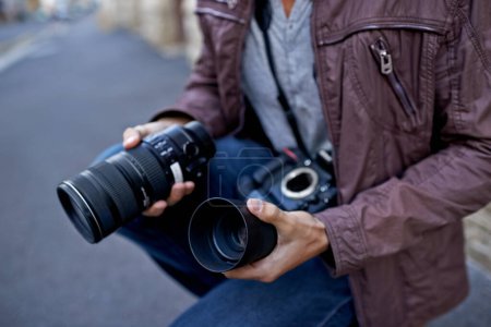 Photo for Camera lens, outdoor and hands of photographer to work in city on photoshoot with professional gear to film on street. Shooting, photography and cameraman closeup with tech to capture media in town. - Royalty Free Image