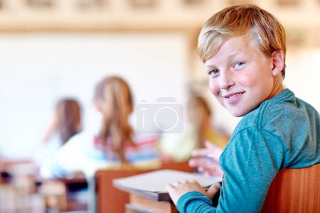 Photo for Child, portrait and school desk with notebook for education in teaching lesson or knowledge, development or scholarship. Boy, face and smile or writing in classroom for project, learning or studying. - Royalty Free Image