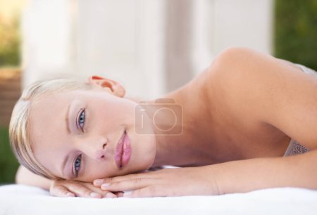 Photo for Spa, woman and portrait on massage bed with relax for wellness, zen and beauty treatment for body care. Person, face and stress relief at resort, salon table and peaceful on holiday or vacation. - Royalty Free Image